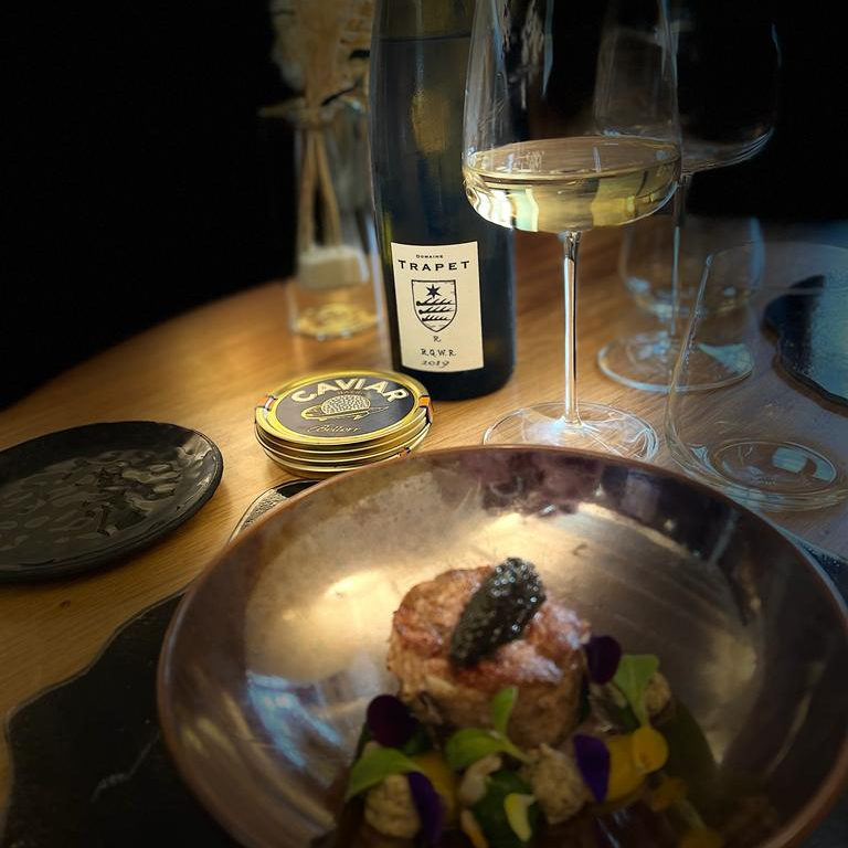 Un plat de l'Évidence avec du caviar et le vin blanc Trapet